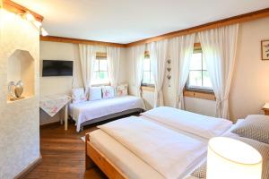 1 dormitorio con 2 camas y 2 ventanas en Auerhof en Schladming