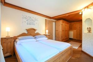 Cama grande en habitación con paredes de madera en Auerhof, en Schladming