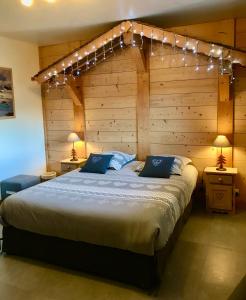 a bedroom with a large bed with lights above it at Chalet coup de coeur in Passy