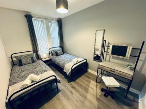 a bedroom with two beds and a mirror at Spanish City View, Stylish Sea Front Apartment Free Onsite Parking in Whitley Bay