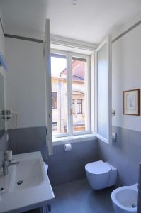 baño con aseo y lavabo y ventana en B&B Cangrande di Danese-Viviani, en Verona