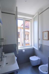 a bathroom with a toilet and a sink and a window at B&B Cangrande di Danese-Viviani in Verona