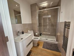 e bagno con servizi igienici, lavandino e doccia. di Brand New Trafford Apartment a Manchester