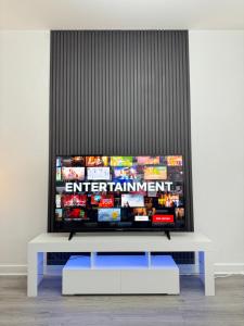 a flat screen tv sitting on top of a white table at Spanish City View 1, Stylish Sea Front Apartment Free Onsite Parking in Whitley Bay