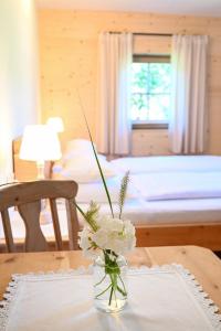 eine Vase mit Blumen auf einem Tisch in einem Schlafzimmer in der Unterkunft Auerhof in Schladming