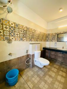 a bathroom with a toilet and a sink at Tulips Residency - Airport in Pīlamedu