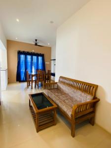 a living room with a couch and a table at Tulips Residency - Airport in Pīlamedu