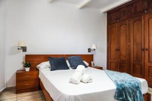 a bedroom with a large white bed with blue pillows at Gomera Playa 1, San Sebastián in San Sebastián de la Gomera