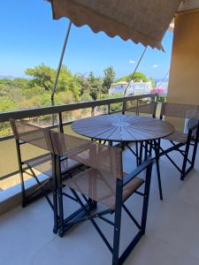 un tavolo e sedie su un balcone con vista di Zouberi Twins Luxury Appartements (North) a Nea Makri