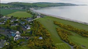 an aerial view of a golf course next to the ocean at The Mended Drum in Fortrose