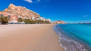 a sandy beach with buildings and the ocean at R-1-Комната в квартире для 2 человек -Alicante centro in Alicante