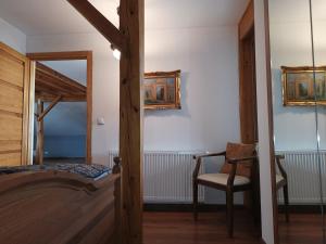 a bedroom with a bed and a chair at Barytowy apartament in Tarnowskie Góry