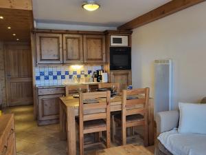 een keuken met een tafel en stoelen in een kamer bij Ecrins A4, 2 bedroom apartment, central Samoëns in Samoëns