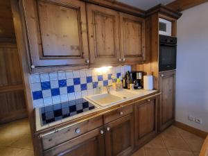 een keuken met houten kasten en een wastafel bij Ecrins A4, 2 bedroom apartment, central Samoëns in Samoëns