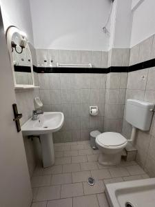 a bathroom with a white toilet and a sink at Villa Spyros in Syvota