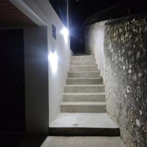 un escalier de nuit avec des lumières sur le mur dans l'établissement Casinha da Sobreira, à Penacova