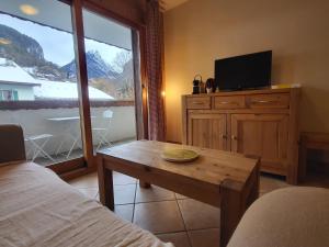 a room with a bed and a table and a tv at Ecrins A4, 1 bedroom apartment with bunk room, central Samoëns in Samoëns +11 photos