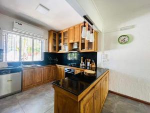 a kitchen with wooden cabinets and a black counter top at Villa Cococherie in Poste Lafayette