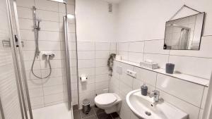 a bathroom with a shower and a toilet and a sink at Central for 8 - 2 Apartments - 2 kitchen - 4 beds in Bochum