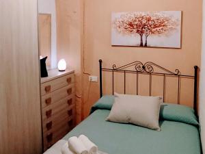 a bedroom with a bed and a dresser and a tree at El almendro de Maruja in Torviscón +26 photos
