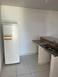 a kitchen with a white refrigerator and a sink at Reis Veloso in Parnaíba
