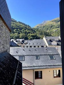 - une vue sur un bâtiment avec des montagnes en arrière-plan dans l'établissement À 50m du centre & des télécabines, nid douillet, à Cauterets