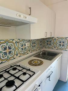 a kitchen with a stove top and a sink at B&B Acireale - Il Cavalluccio Marino Fronte Mare in Acireale