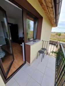 a balcony with a glass door and a chair at BookMeNow in Viforîta