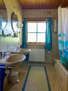 baño con 2 lavabos, bañera y ventana en Lepahn Holsteinische Schweiz, en Lehmkuhlen