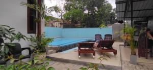 a pool with chairs and a table in front of it at Kutumbaya in Anuradhapura