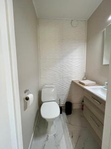 a white bathroom with a toilet and a sink at Pieni omakotitalo joen rannalla in Rautio