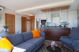 salon z niebieską kanapą i kuchnią w obiekcie Luxury sea view apartment & pool w mieście Mijas