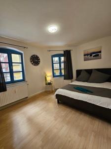 a bedroom with a bed and a clock on the wall at B&R Ganze Apartment Süd Nürnberg in Nürnberg