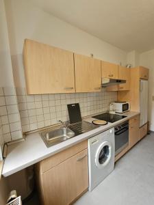 a kitchen with a sink and a washing machine at B&R Ganze Apartment Süd Nürnberg in Nürnberg +12 photos