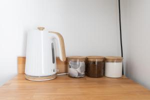 a kitchen counter with three jars and a blender at Bay City Studio Apartments in Cardiff