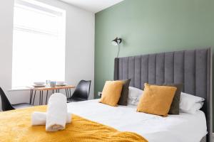 卡地夫的住宿－Bay City Studio Apartments，一间卧室配有一张带黄色枕头的大床