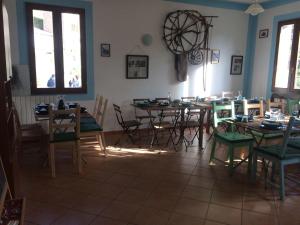 a dining room with tables and chairs and windows at Pania forata hostel in Stazzema