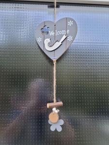 a heart ornament hanging from a window with a flower at Rheinauszeit in Rheinbrohl