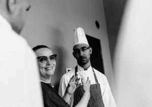 un homme dans un chapeau de chef debout devant un miroir dans l'établissement Uve Rooms & Wine Bar, à La Morra