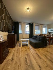 a living room with a couch and a table at Apartament Oksford 1 in Okszów