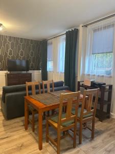 a living room with a table and chairs and a couch at Apartament Oksford 1 in Okszów
