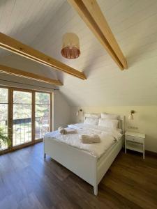 ein Schlafzimmer mit einem großen weißen Bett im Dachgeschoss in der Unterkunft Luxury Villa Pitraga Viļņi in Pitragutsiyeme