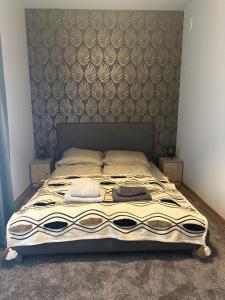 a bedroom with a bed with a large headboard at Apartament Oksford 1 in Okszów