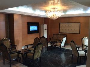 a waiting room with chairs and a tv and a chandelier at Ilıcak Hotel in Istanbul