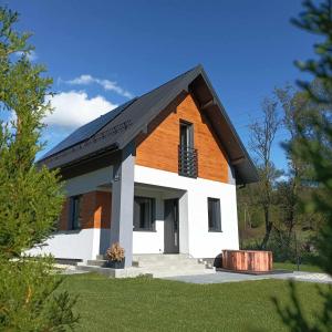 Casa blanca y marrón con techo negro en Domek nad potokiem, en Grywałd
