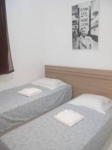 Cette chambre dispose de 2 lits jumeaux et d'une affiche murale. dans l'établissement Privilégio em Cabo Frio, à Cabo Frio