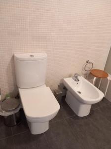 a bathroom with a white toilet and a sink at Casa do Brasão in Lajes do Pico