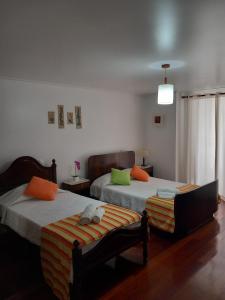 1 dormitorio con 2 camas y ventana en Casa do Brasão en Lajes do Pico