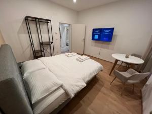 ein Schlafzimmer mit einem weißen Bett und einem Tisch in der Unterkunft Apartment 19 near Metro & Netflix in Wien