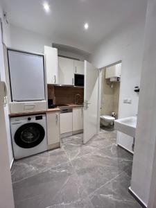 eine Küche mit einer Waschmaschine und einem Waschbecken in der Unterkunft Apartment 19 near Metro & Netflix in Wien